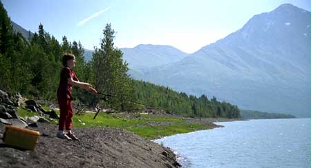 Boy fishing in mountain lake